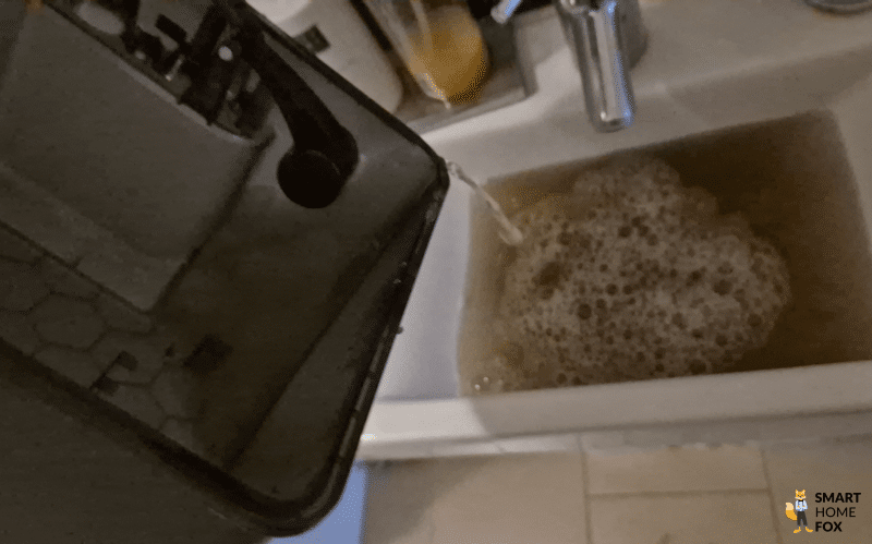 Der Schmutzwassertank des Roborock Saros 10 wird am Waschbecken ausgeleert.